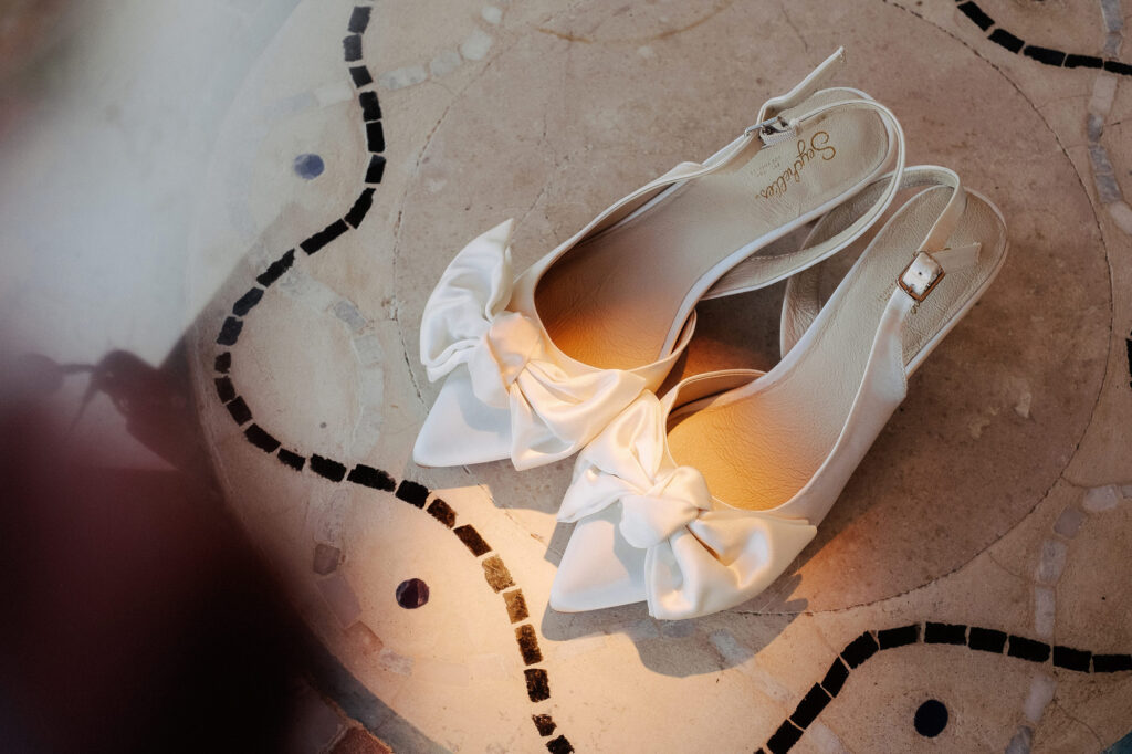 White satin bow bridal shoes by Seychelles on mosaic tile floor at Villa Amor Sayulita wedding