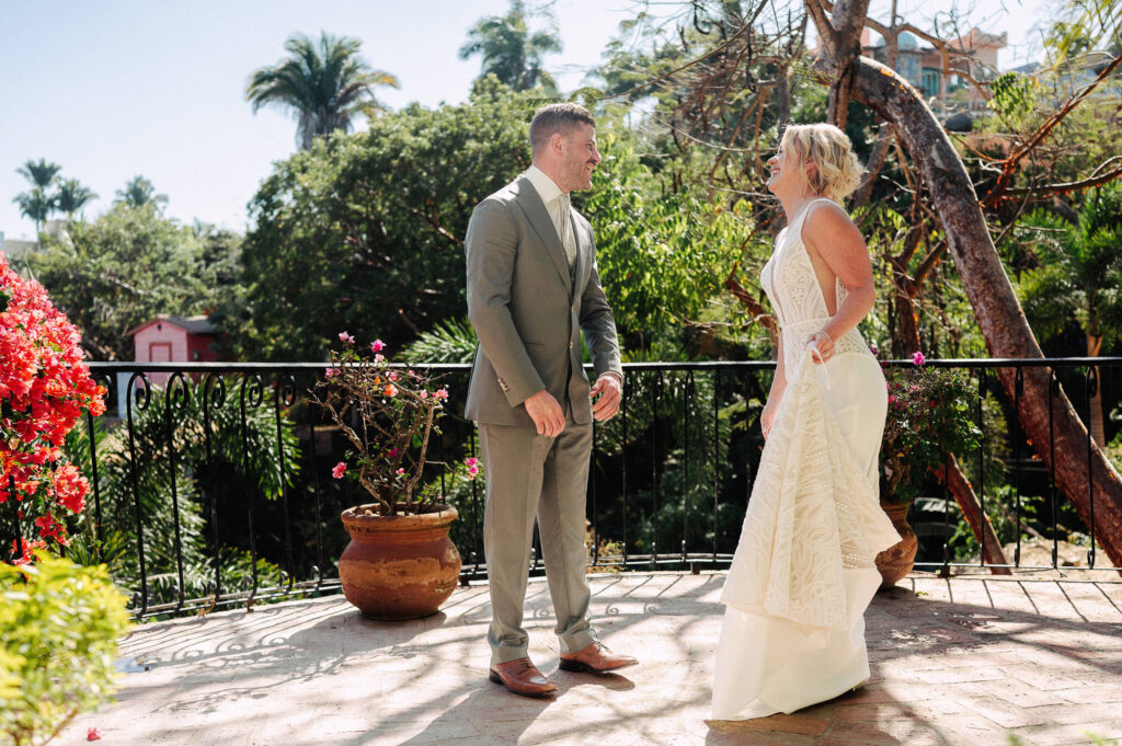 Bride and groom laughing together on terrace at Villa Amor Sayulita wedding, surrounded by tropical blooms