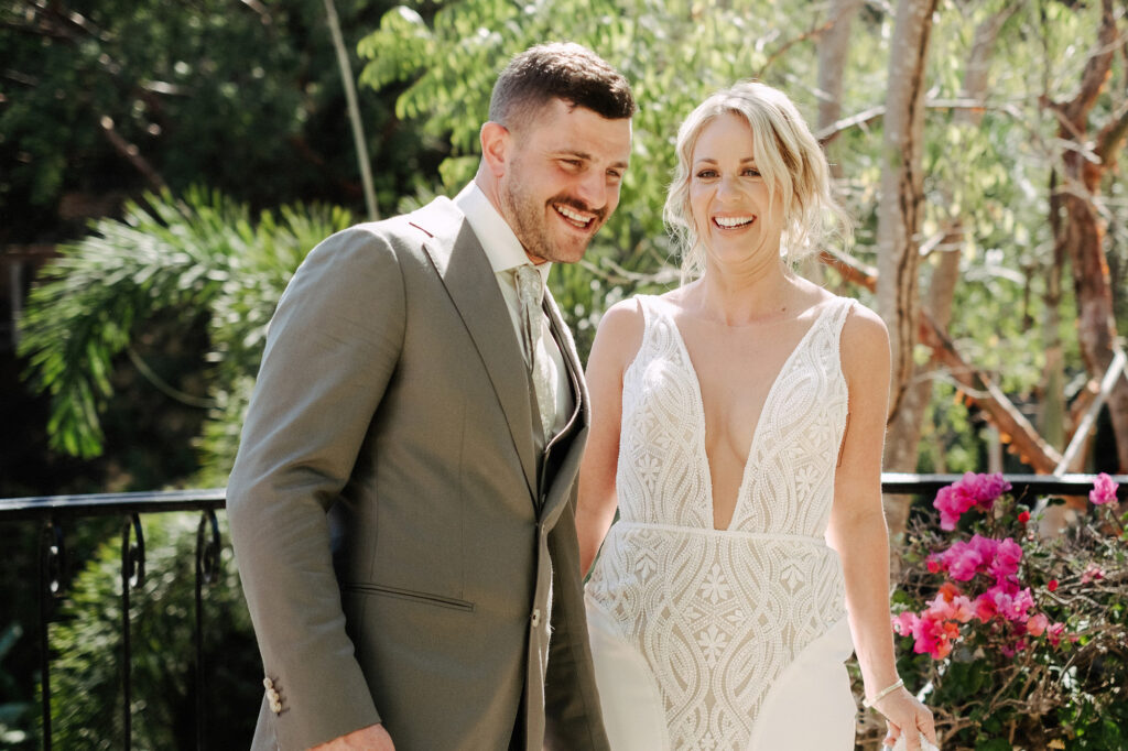 Bride and groom laughing together at Villa Amor Sayulita wedding ceremony, lush tropical garden background