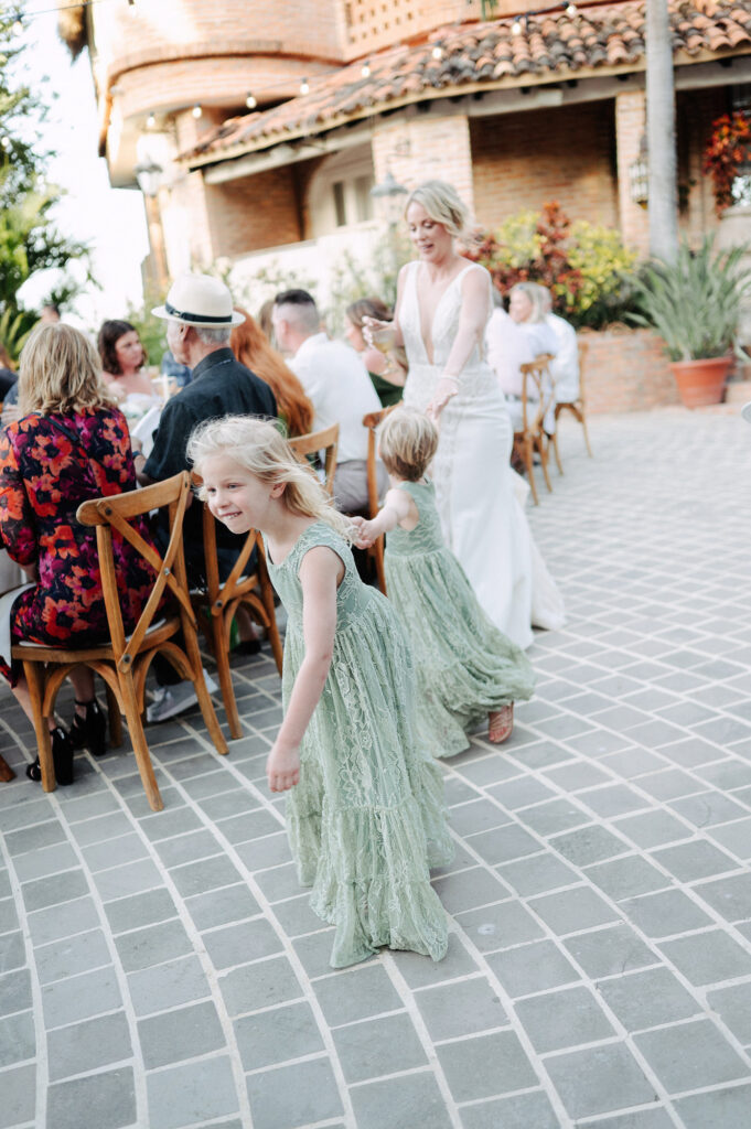 Flower girls in sage lace dresses dancing at outdoor wedding reception, Villa Amor Sayulita Mexico