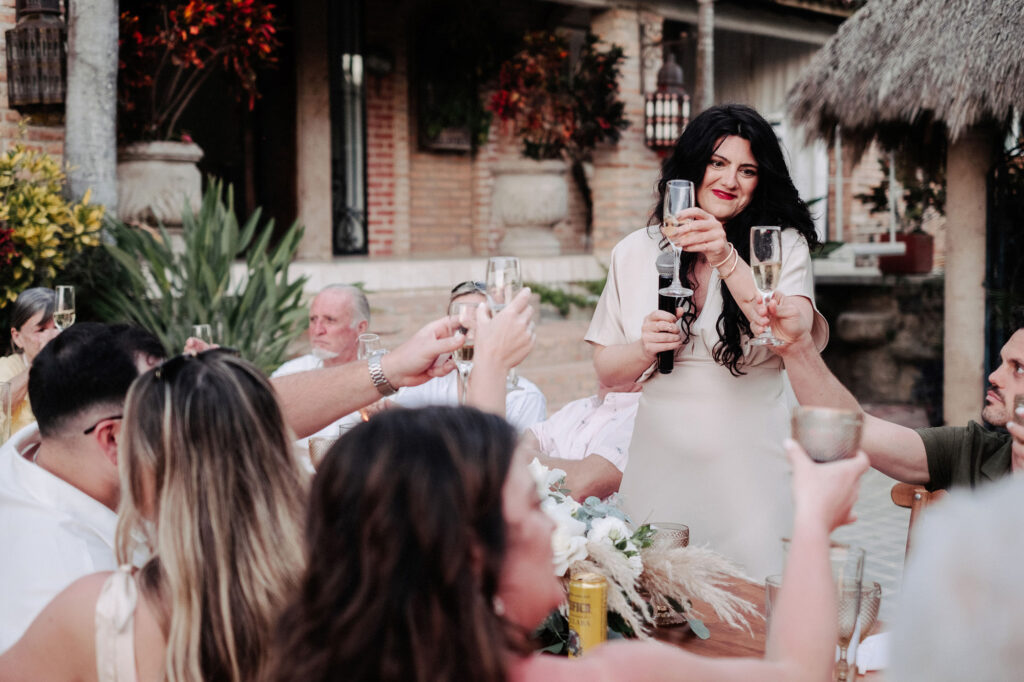 Wedding toast at Villa Amor Sayulita, guests raising champagne glasses during outdoor reception