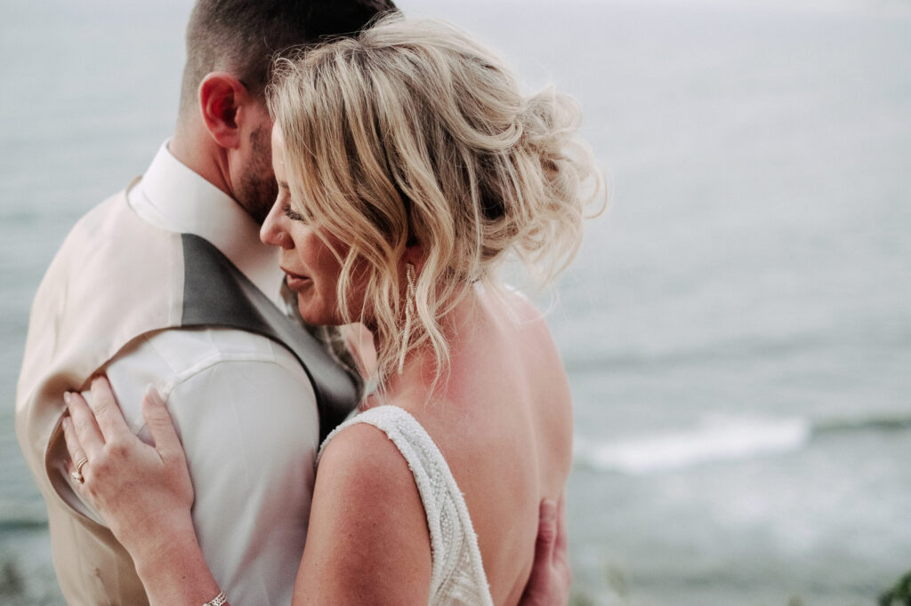 Bride and groom embrace by the ocean at Villa Amor Sayulita wedding, documentary style photography