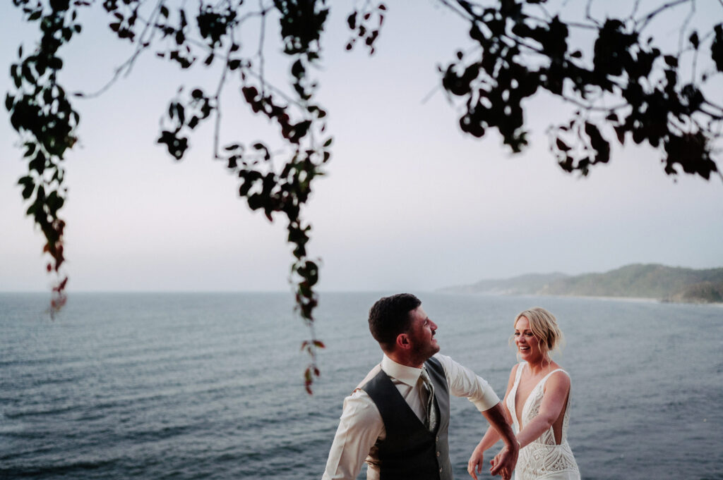 Bride and groom laughing together at Villa Amor Sayulita with ocean views, documentary wedding photo by Alex Obregón