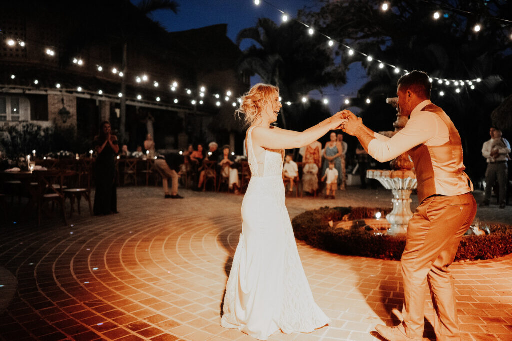 Bride and groom share first dance under string lights at Villa Amor Sayulita wedding reception at night