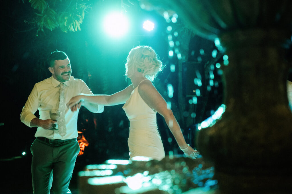 Bride and groom dancing under teal lights at Villa Amor Sayulita wedding reception