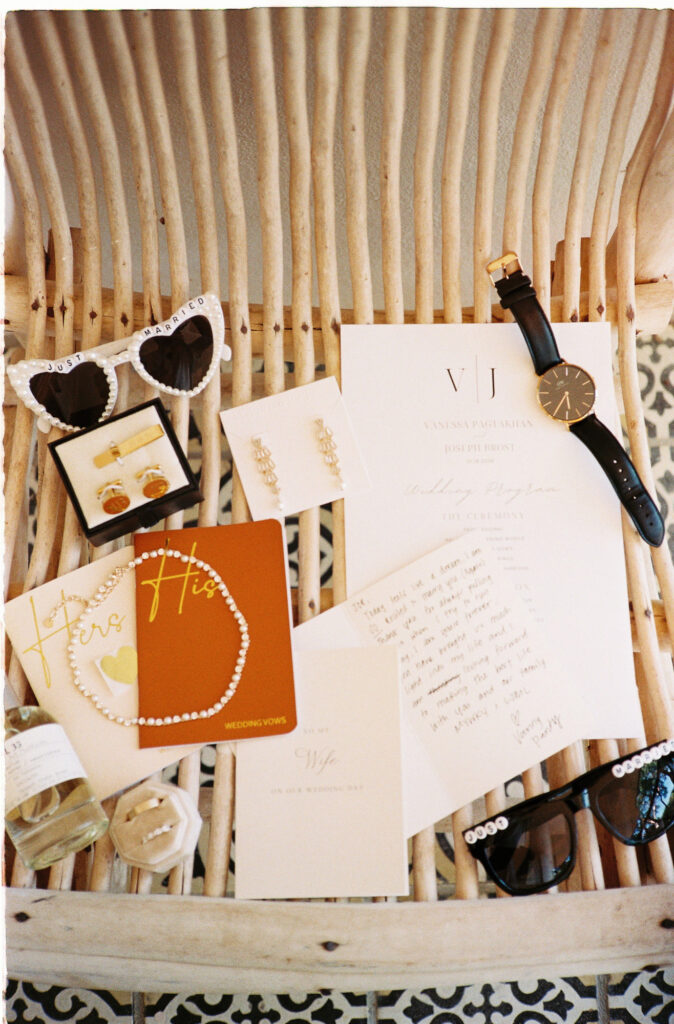Wedding flat lay with vows, program, watch, and just married sunglasses at Villa Valentin Sayulita