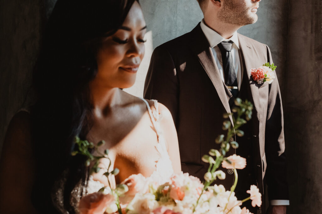 Bride holding coral bouquet with groom in gray suit at Villa Valentin Sayulita wedding ceremony