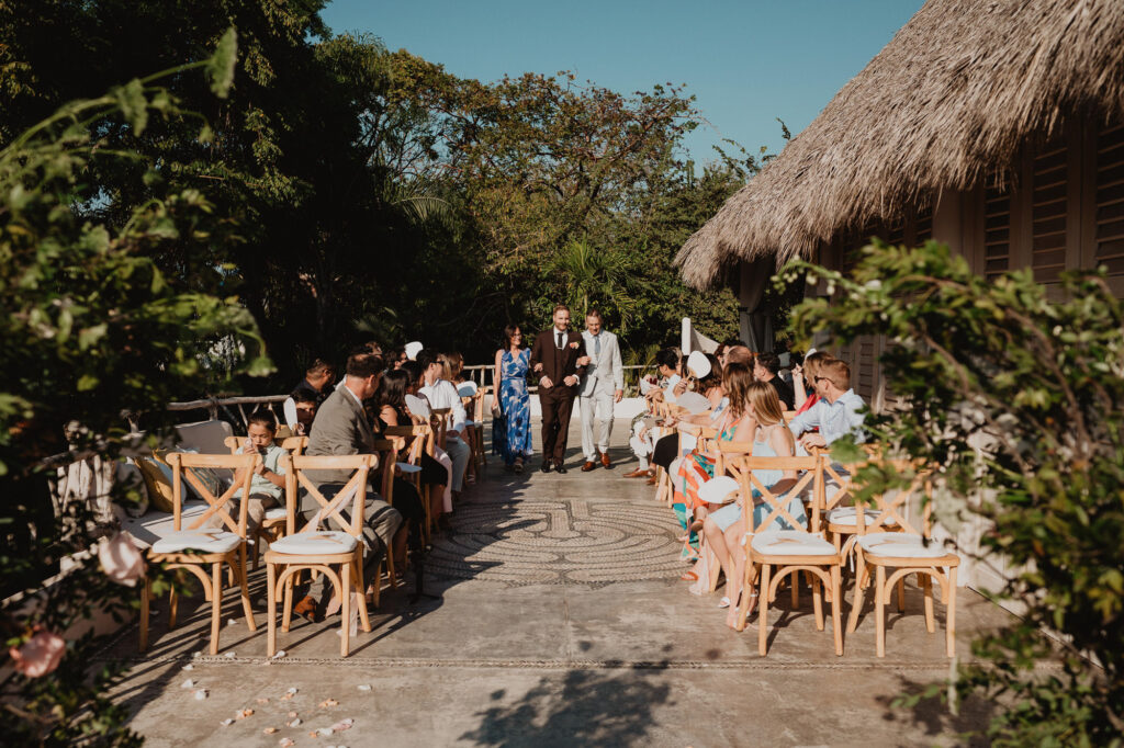 Wedding ceremony processional at Villa Valentin Sayulita, guests seated in wooden chairs outdoors