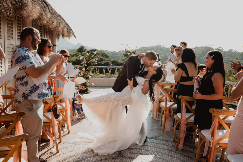 Bride and groom share a dip kiss at their outdoor wedding ceremony at Villa Valentin, Sayulita, Mexico