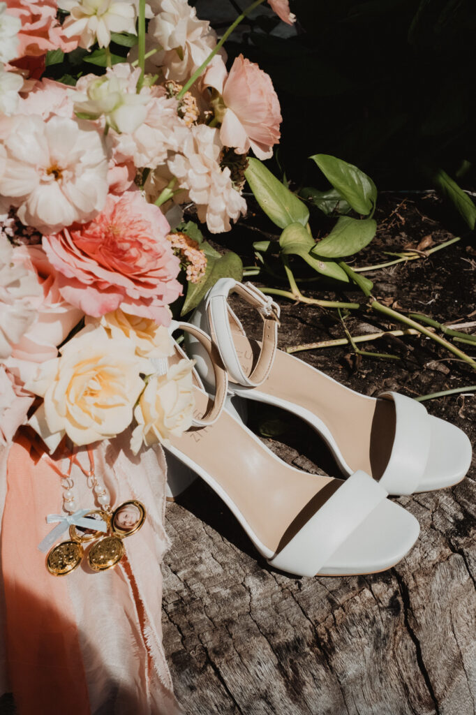 Bridal heels, bouquet, and locket charm on a log at Villa Valentin, Sayulita wedding
