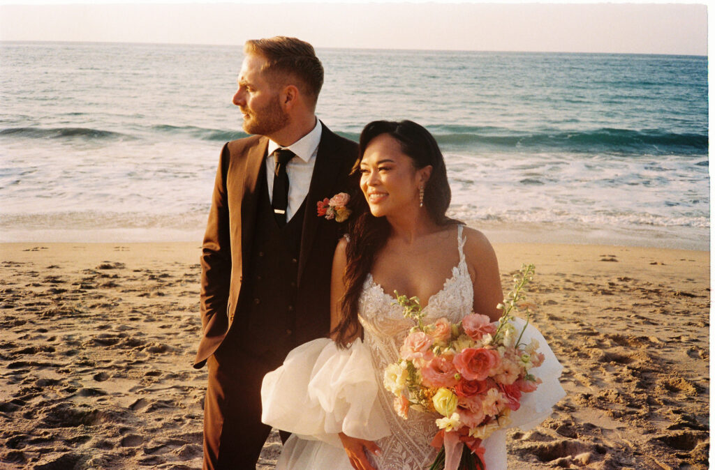 Bride and groom on the beach at Villa Valentin Sayulita, bride holding colorful bouquet at golden hour