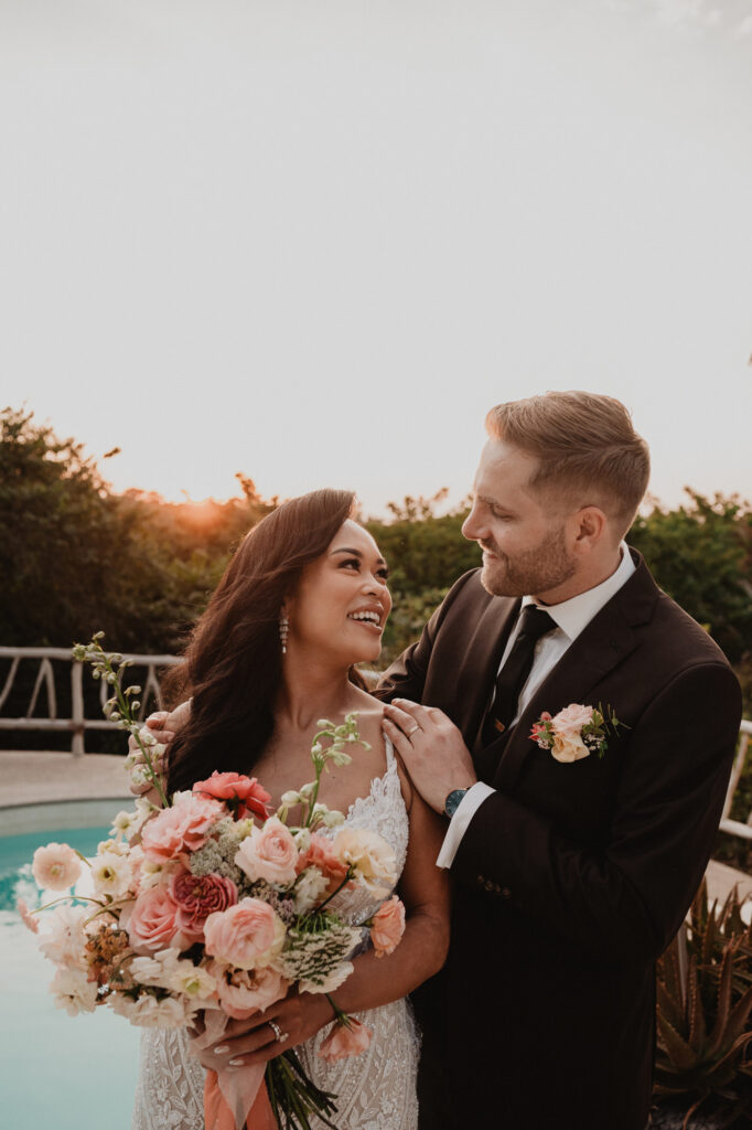 Bride and groom share a joyful moment by the pool at Villa Valentin, Sayulita wedding reception