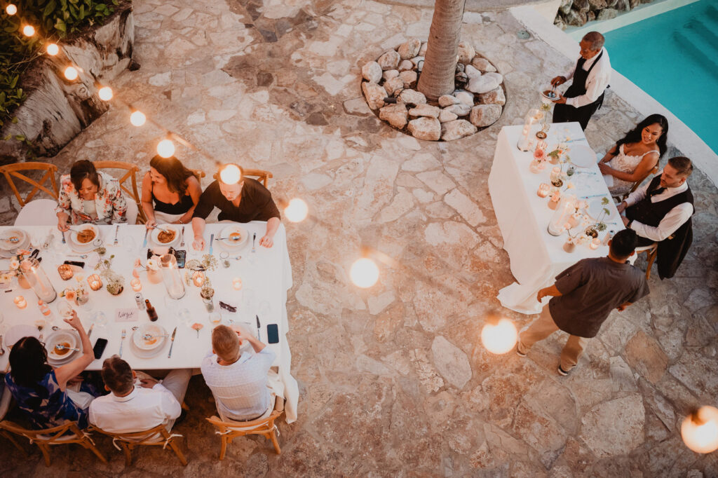 Aerial view of outdoor wedding reception dinner at Villa Valentin Sayulita with string lights and pool