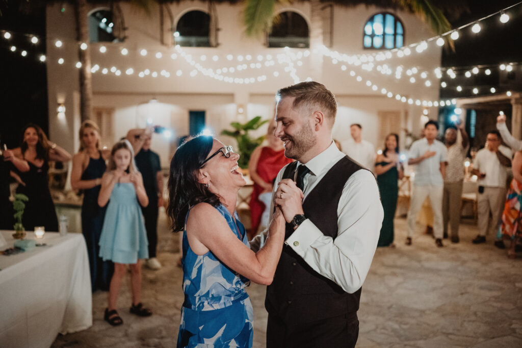 Groom dancing with mother at outdoor wedding reception, Villa Valentin Sayulita, string lights overhead