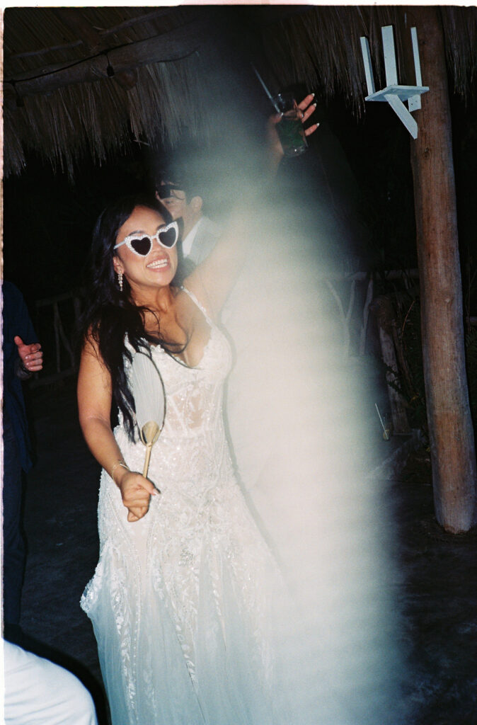 Bride in lace gown and heart sunglasses dancing at wedding reception, Villa Valentin Sayulita film photo