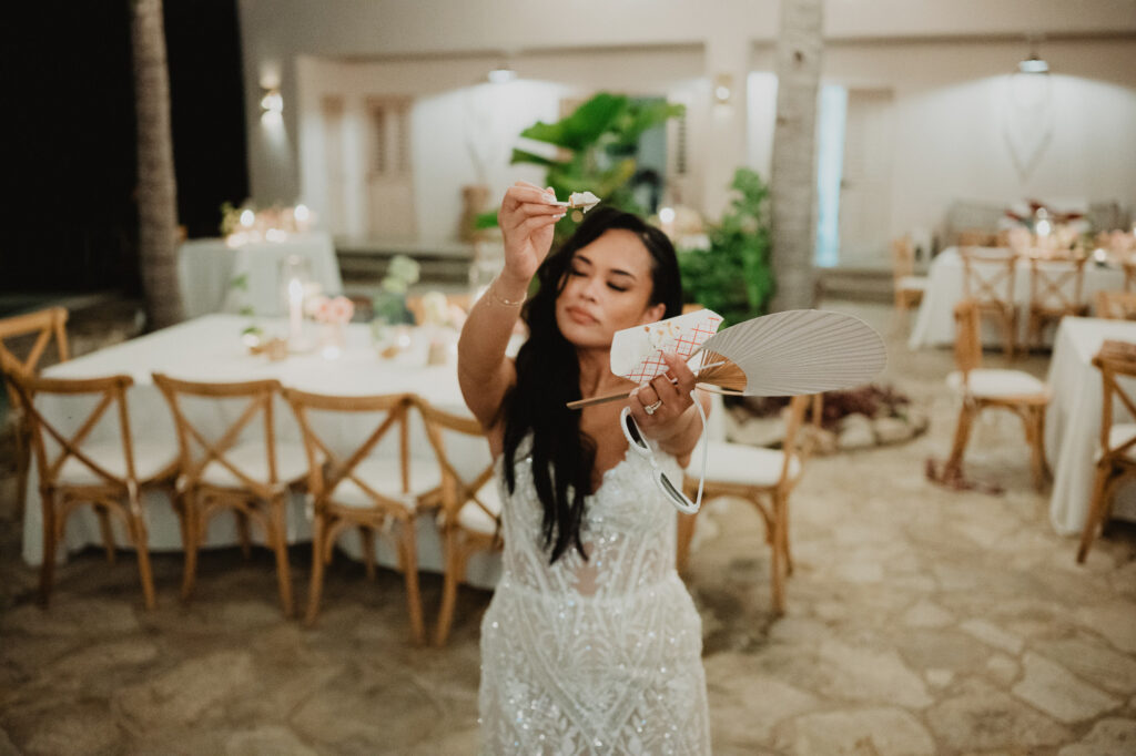 Bride holding a hand fan and flower at Villa Valentin Sayulita wedding reception, photographed by Alex Obregón