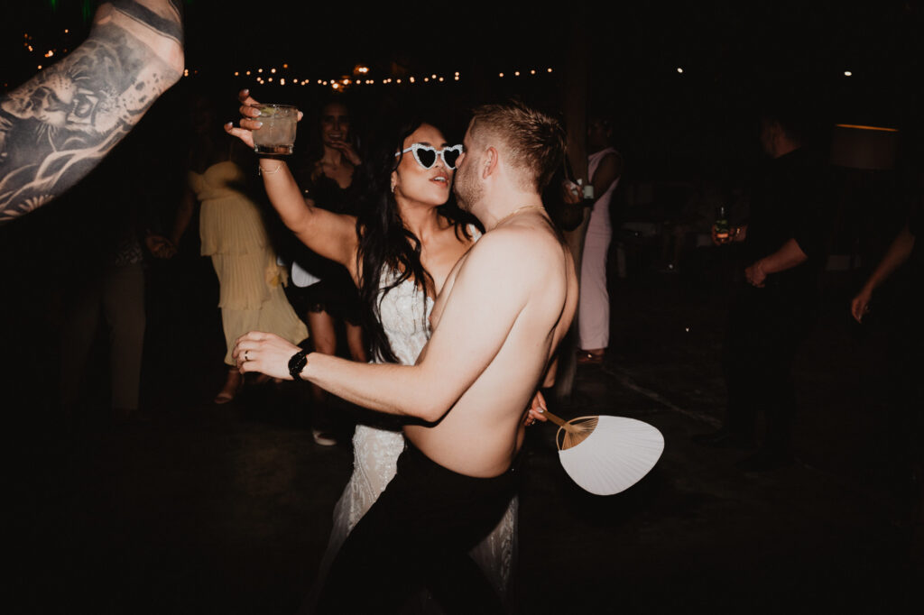 Bride and groom dancing at night wedding reception, Villa Valentin Sayulita, heart sunglasses and string lights