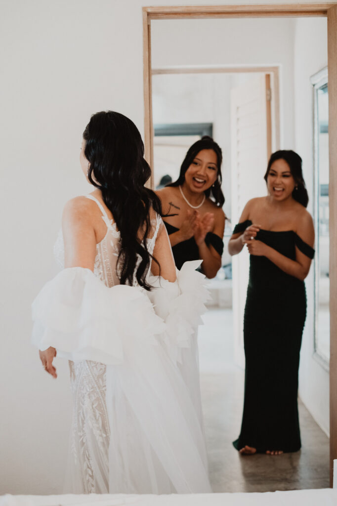 Bride reveals wedding dress to bridesmaids in black gowns, getting ready at Villa Valentin Sayulita