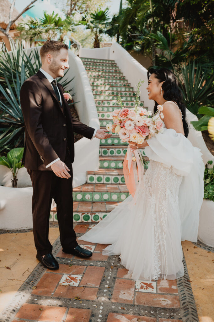 Bride and groom sharing a joyful first look on tiled stairs at Villa Valentin, Sayulita wedding