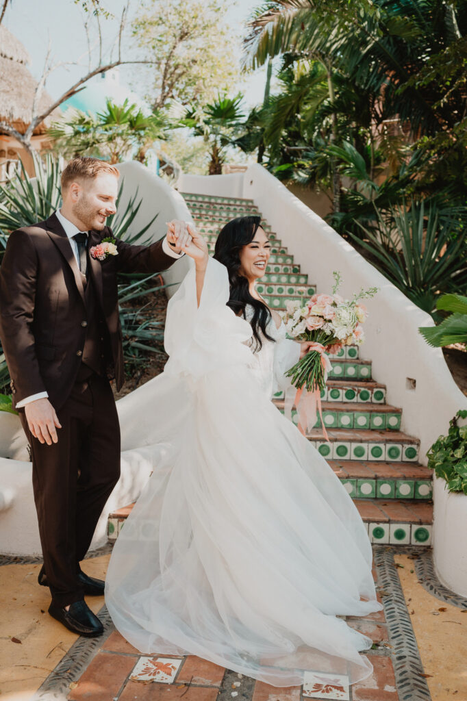 Bride and groom laughing on tiled steps at Villa Valentin Sayulita wedding, documentary style