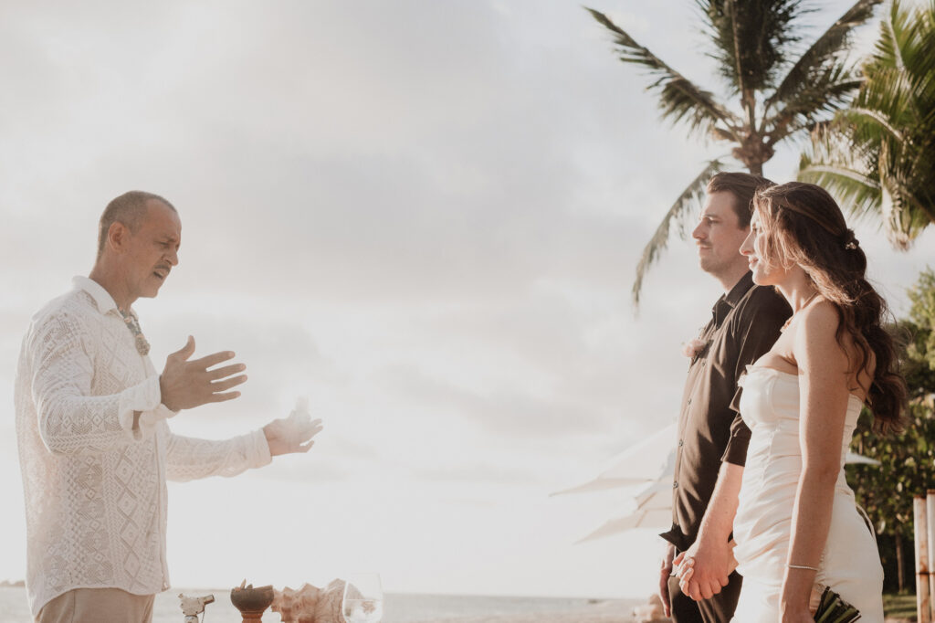 Elopement ceremony at St Regis Punta Mita, couple holds hands as officiant speaks oceanside