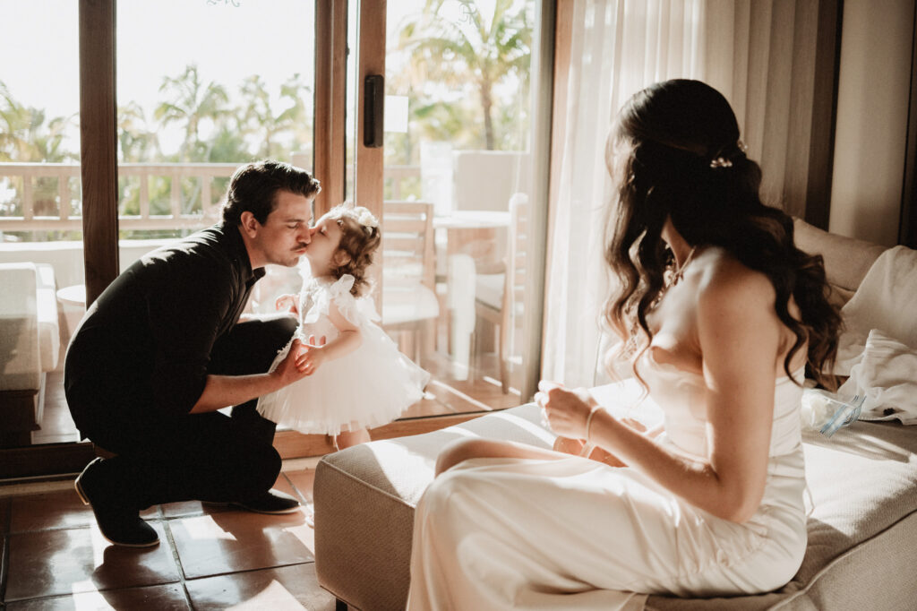 Bride and groom share a tender moment with their flower girl during elopement at St Regis Punta Mita