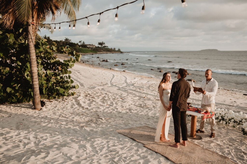 Beach elopement ceremony at St Regis Punta Mita, couple holding hands at sunset with ocean backdrop