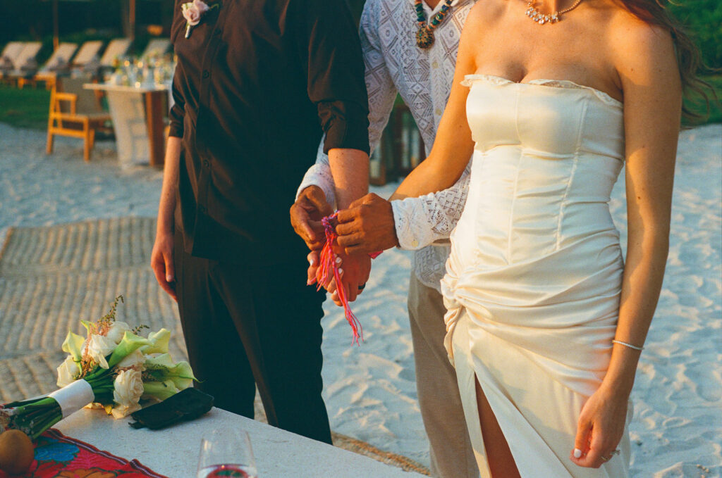 Handfasting ceremony detail at elopement wedding, St Regis Punta Mita, bride in strapless gown on sandy beach