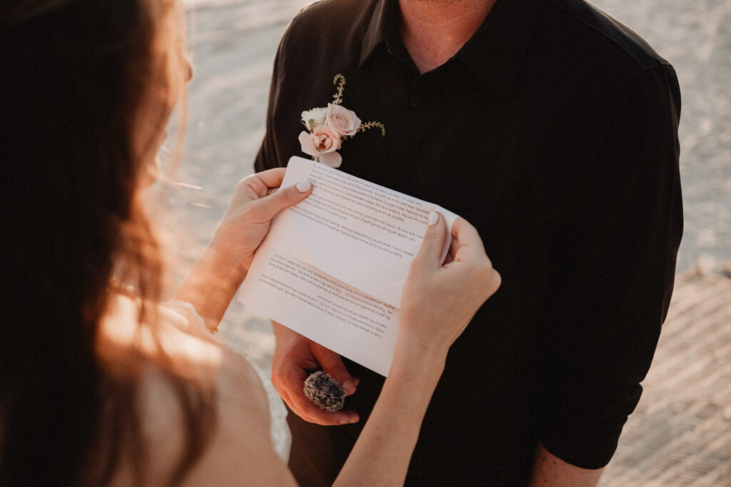 Bride reading handwritten vows during elopement at St Regis Punta Mita, Mexico