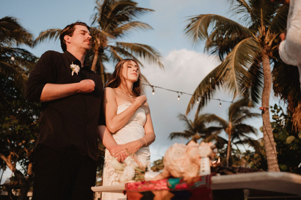Bride and groom sharing a quiet moment at their Punta Mita elopement, palm trees and golden light overhead