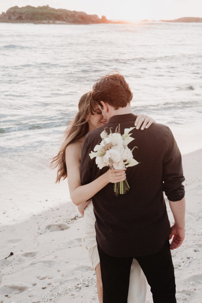 Couple embracing at sunset on the beach during elopement at St Regis Punta Mita, Mexico