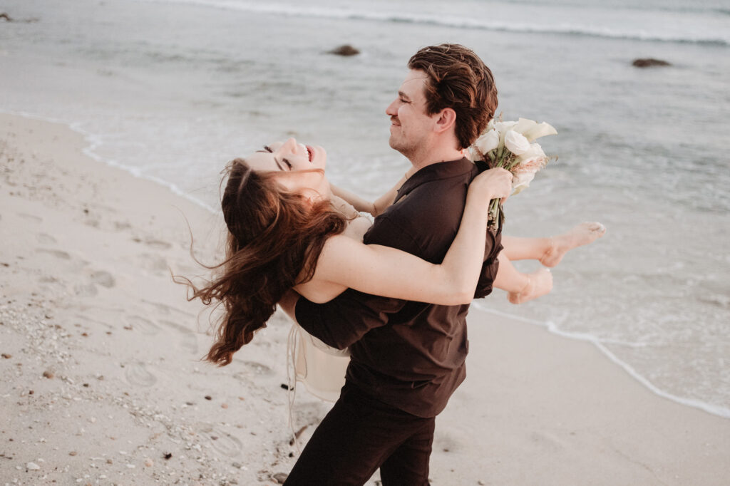 Couple laughing and spinning on beach during elopement at St Regis Punta Mita by Alex Obregón