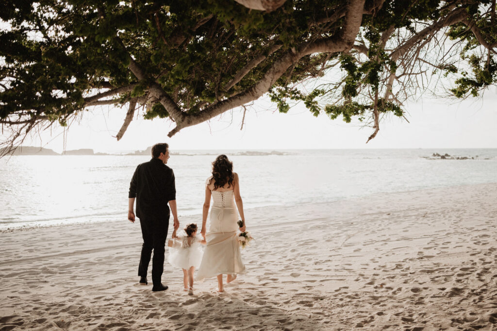 Bride and groom walking on beach with toddler at sunset, elopement at St Regis Punta Mita Mexico