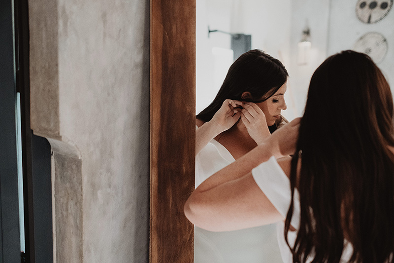 Bride putting on earrings before wedding ceremony at Ambre & Epieces Tulum, documentary wedding photography