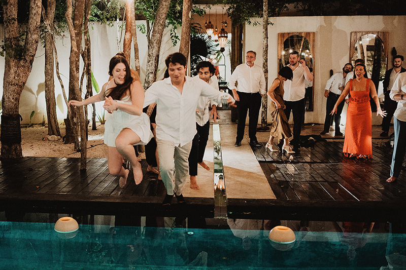 Couple jumping into pool at Tulum wedding reception, Ambre & Epieces, documentary wedding photography