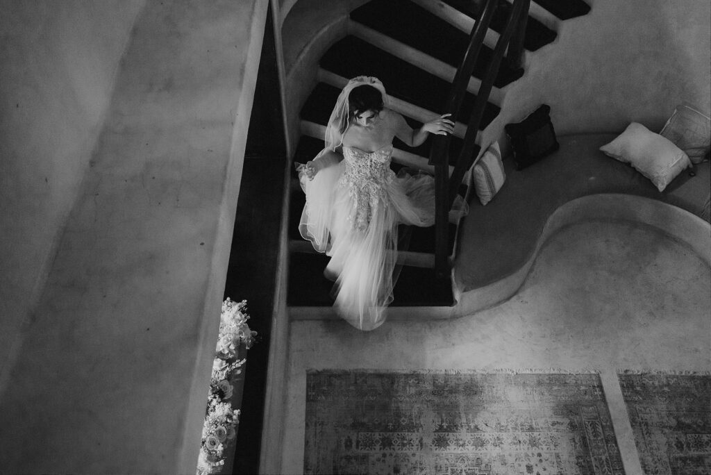 Bride descending spiral staircase in lace gown and veil at Papaya Playa Project, Tulum wedding