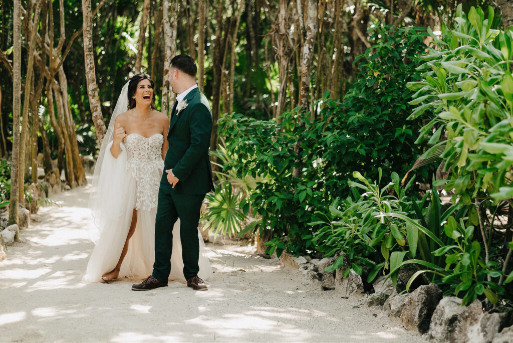 Bride and groom laughing together on sandy jungle path at Papaya Playa Project Tulum wedding