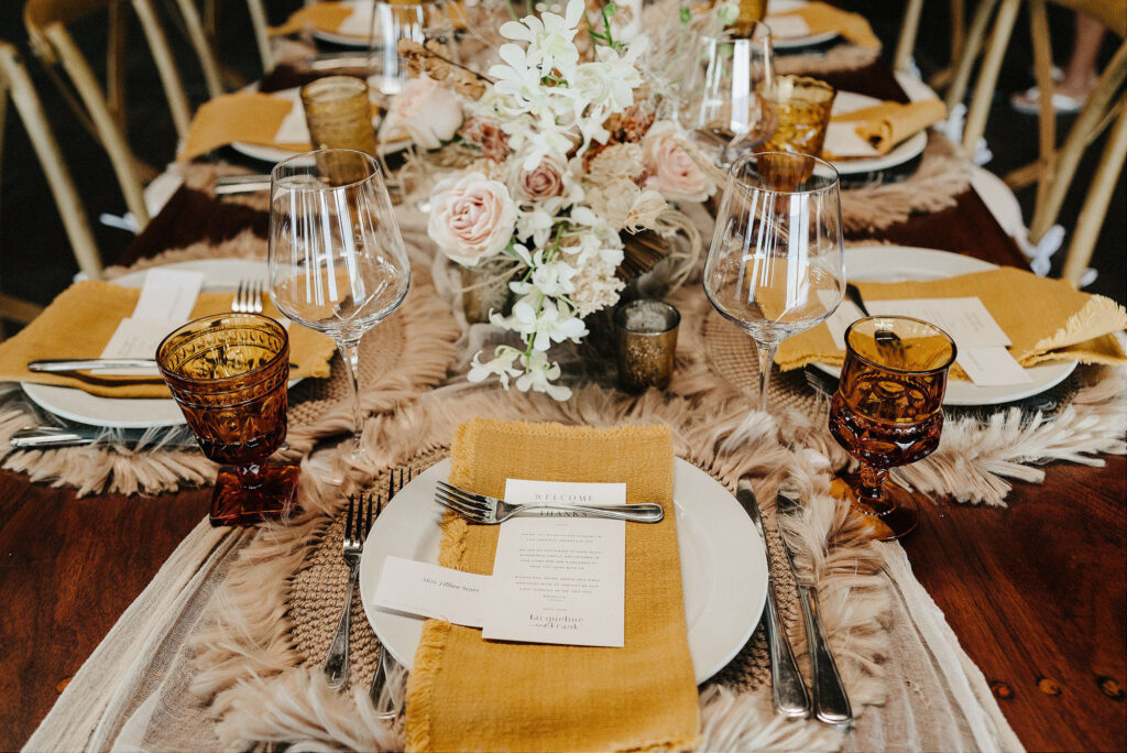 Boho wedding reception tablescape with amber glassware and blush florals at Papaya Playa Project Tulum