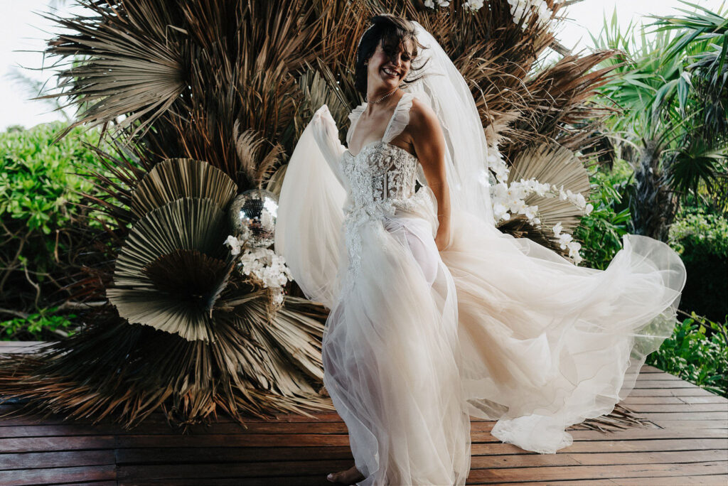 Bride twirling in lace corset gown at Papaya Playa Project, Tulum wedding ceremony, boho tropical backdrop