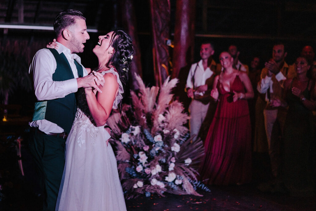 Bride and groom share first dance at Papaya Playa Project Tulum wedding reception, guests cheering