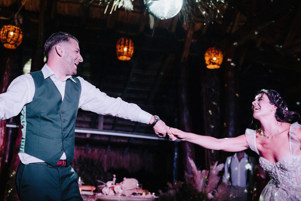 Bride and groom laughing while dancing at Papaya Playa Project wedding reception, Tulum