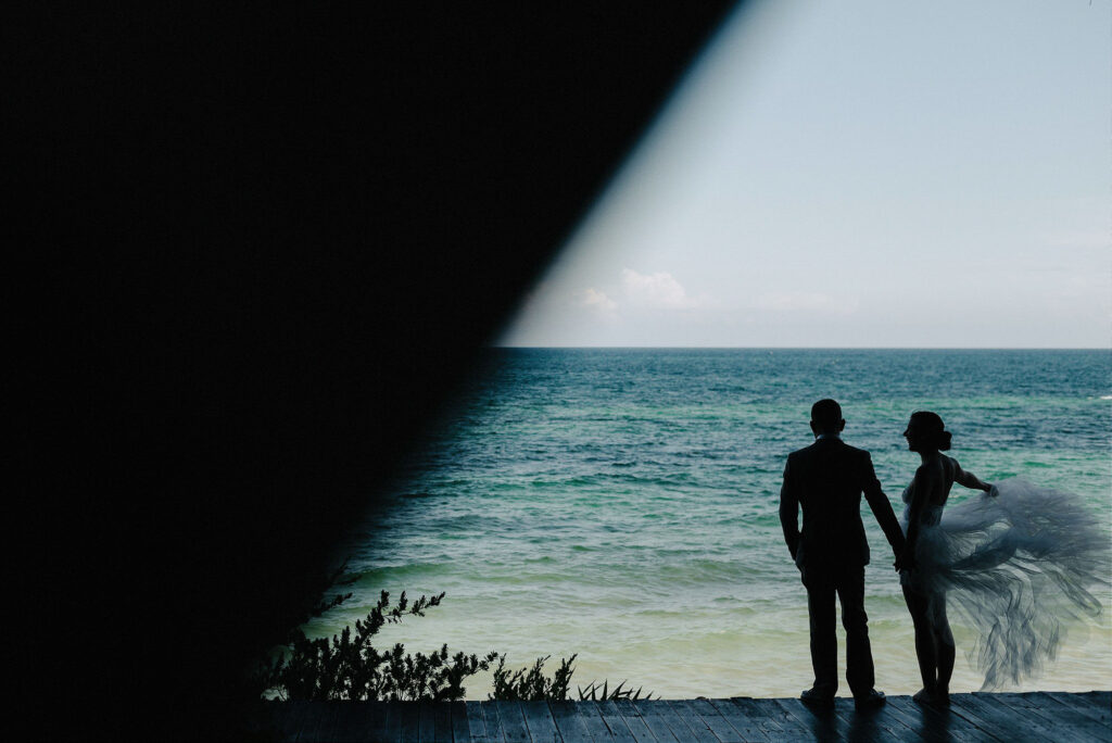 Bride and groom silhouette overlooking turquoise ocean at Papaya Playa Project, Tulum wedding